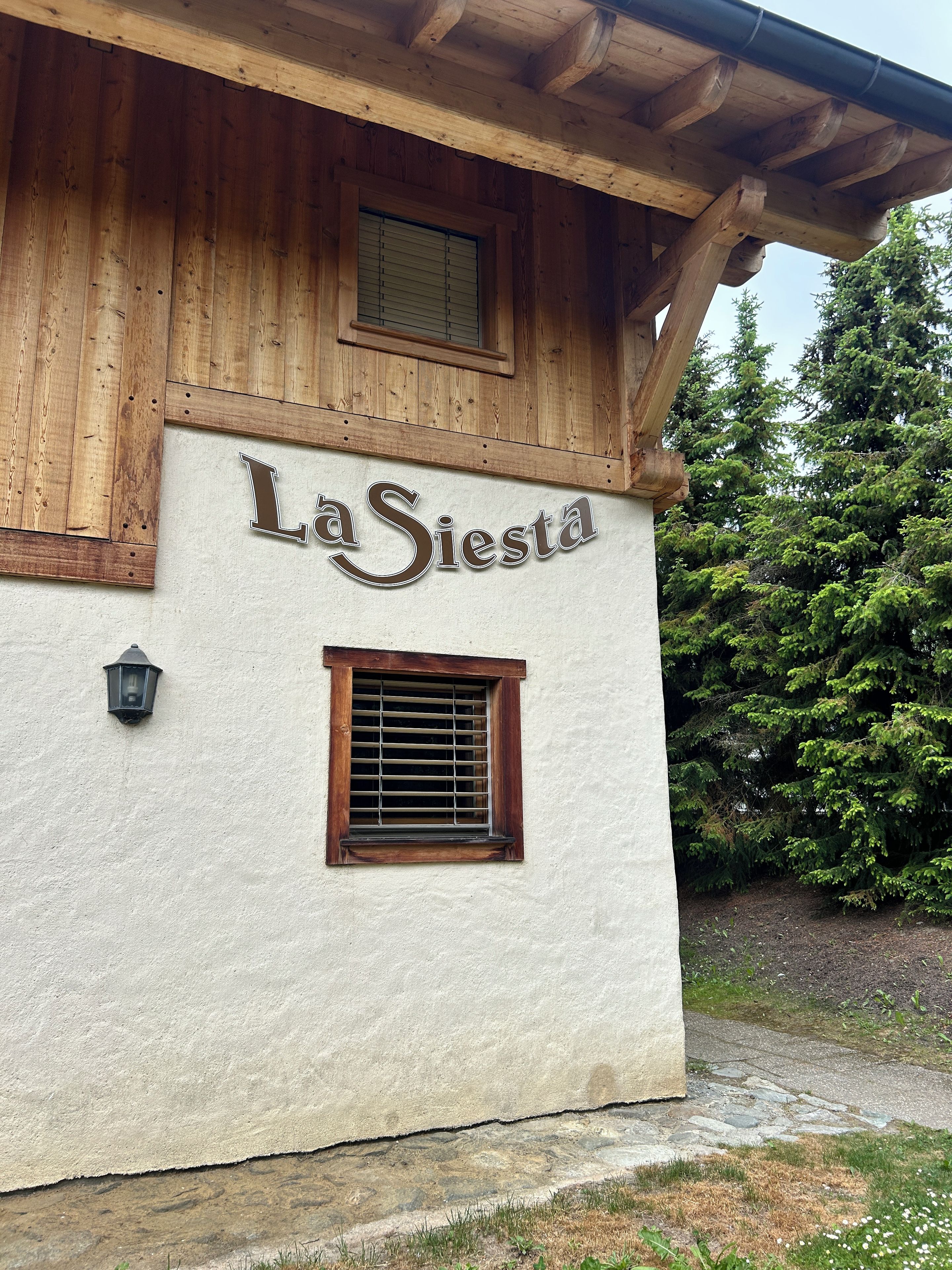 A building with a wooden facade and a sign that reads 'La Siesta.'