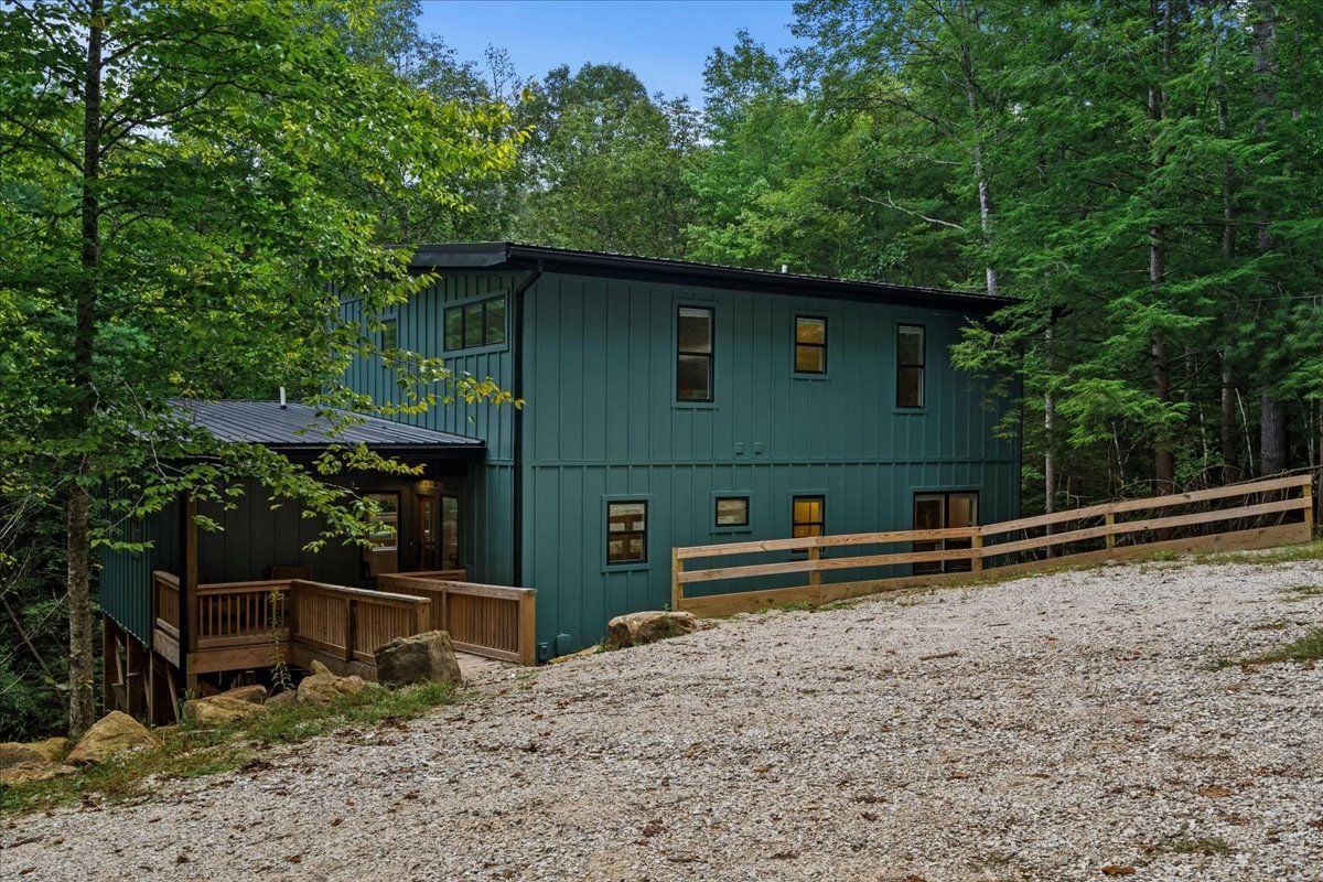 A two-story building with a porch and a wooden fence.