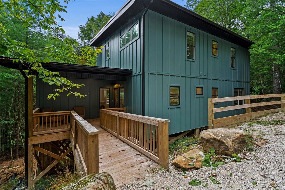 A two-story building with a wooden deck leading to a covered entrance.