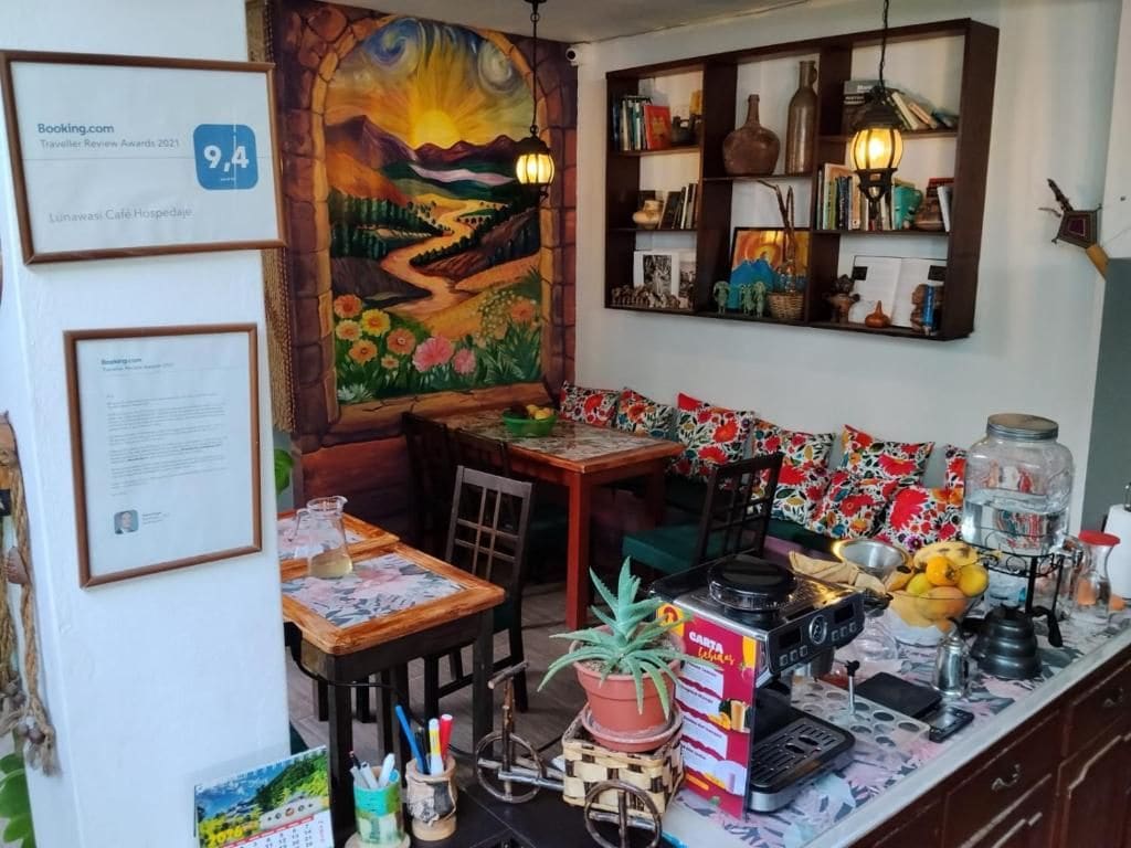 A cozy café with a rustic decor, a mural, and a variety of seating options.