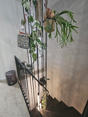 A staircase with a metal railing, potted plants, and a hanging basket. - Marseille, 5th arrondissement: 140 m² duplex + garden + air conditioning (Marseille)