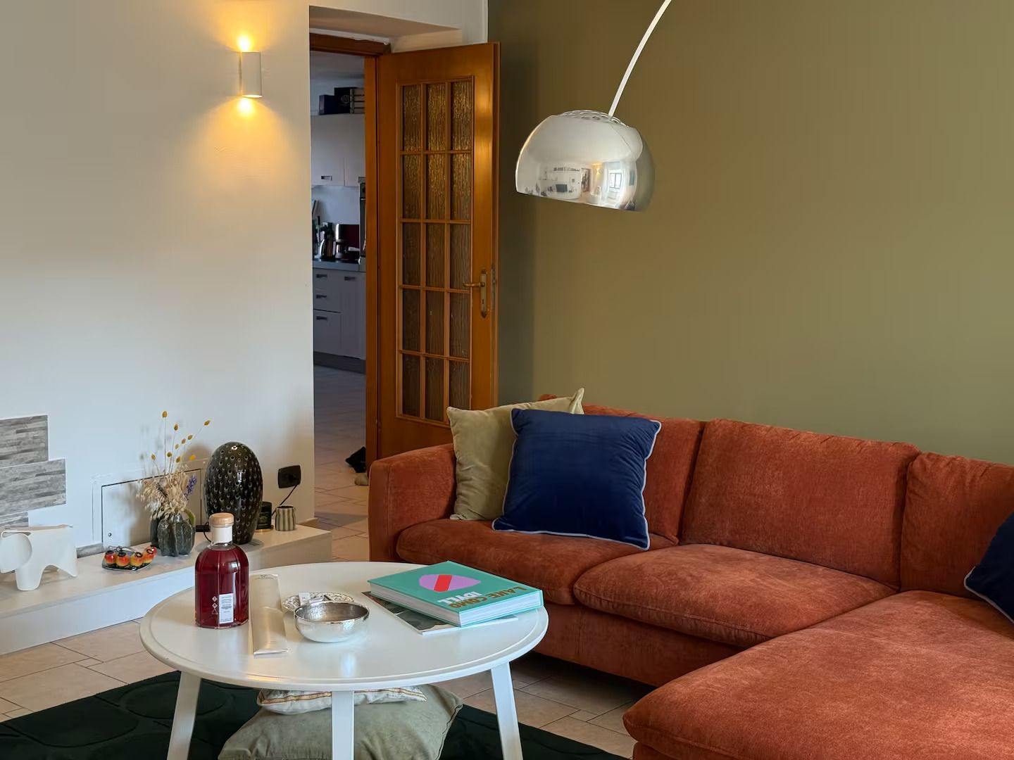 Un soggiorno con un divano, un tavolino da caffè e una lampada a sospensione.