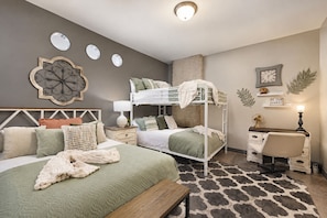 A bedroom with bunk beds, a desk, a chair, a lamp, and a rug. - The Bentley Collection - The Landmark Loft (Dallas)