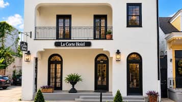 Un hôtel à deux étages doté d’un balcon, de fenêtres en arc de cercle et d’une enseigne indiquant « La Corte Hotel ».