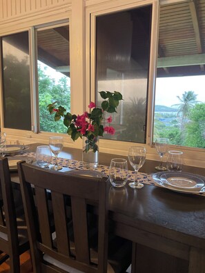 Et spisebord dækket med tallerkener, glas og en vase med blomster.