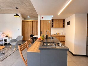 Cozinha moderna com ilha central, armários de madeira e área de jantar com cadeiras e mesa.