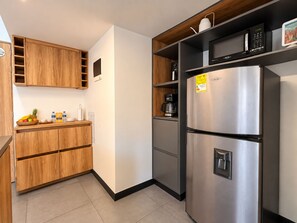 A modern kitchen with wooden cabinets, a stainless steel refrigerator, and a coffee maker. - Amazing Loft in Medellín—Central (Medellín)