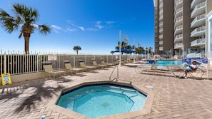 A pool area with lounge chairs, a hot tub, and a fenced poolside. - 2BR Deluxe at Club Wyndham Majestic Sun with Partial Ocean Views in Destin (Miramar Beach)