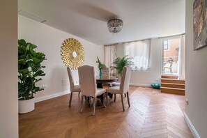 A dining area with a round table, four chairs, and a large mirror on the wall. - Charm and comfort in the heart of Taormina: 3 bedrooms and a private terrace (Taormina)