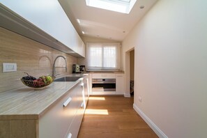 A modern kitchen with a skylight, stainless steel appliances, and a wooden countertop. - Charm and comfort in the heart of Taormina: 3 bedrooms and a private terrace (Taormina)