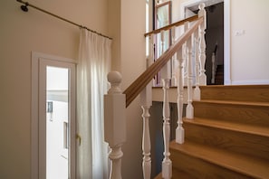 A staircase with white balusters and a wooden handrail leading to an upper floor. - Charm and comfort in the heart of Taormina: 3 bedrooms and a private terrace (Taormina)