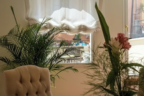 A room with a window, a chair, and a potted plant. - Charm and comfort in the heart of Taormina: 3 bedrooms and a private terrace (Taormina)