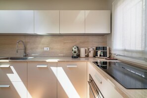 A modern kitchen with a stainless steel sink, a built-in oven, and a coffee maker. - Charm and comfort in the heart of Taormina: 3 bedrooms and a private terrace (Taormina)