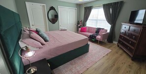 A bedroom with a bed, a dresser, a television, and a window with curtains. - Orlando Emerald Dream House (Kissimmee)