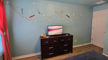 Een kamer met een donkere houten dressoir, een schilderij en twee hangmatten aan de muur.