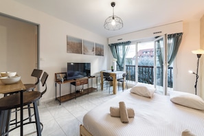 Ein modernes Schlafzimmer mit Bett, Schreibtisch, Fernseher und einem Balkon mit Blick.