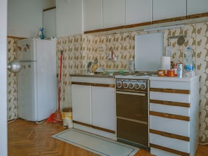 Eine Küche mit Kühlschrank, Herd und Schränken.