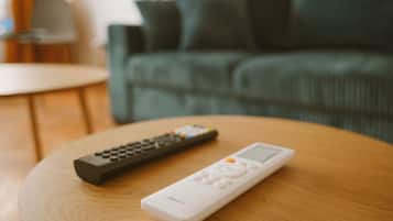 Une télécommande et un appareil blanc sur une table en bois.