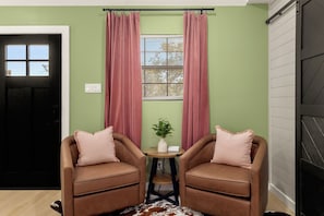 A room with two brown leather chairs, a small table with a plant, and a window with blinds. - Romantic Hill Country Cottage w/ Private Hot Tub (Fredricksburg)