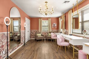 A room with a vanity, two armchairs, a chandelier, and a ring light. - 40-ft Heated Pool & Spa, Sport Court, Game Room (Fredricksburg)