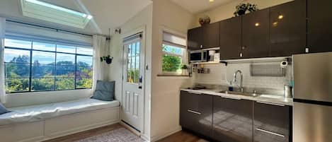 A modern kitchen with a built-in oven, microwave, and stainless steel refrigerator.