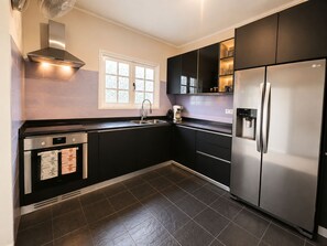 A modern kitchen with a stainless steel refrigerator, a built-in oven, and a sink. - Spacious ground-floor apartment with an ocean-view pool and the beach within walking distance (Willemstad)
