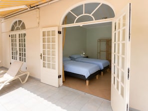 A room with two beds, a chair, and a wardrobe. - Spacious ground-floor apartment with an ocean-view pool and the beach within walking distance (Willemstad)
