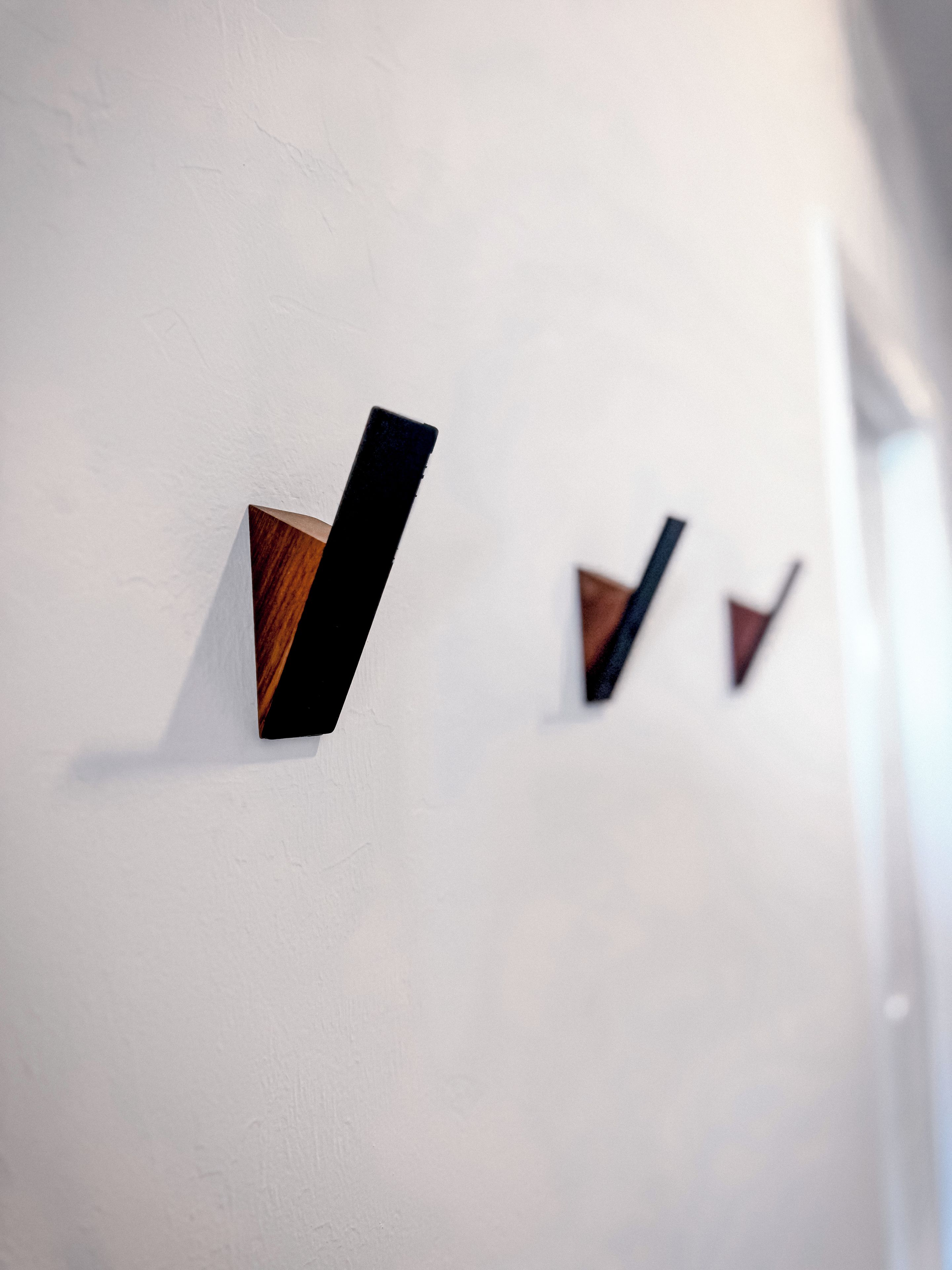 Una pared con tres relojes de pared de madera.