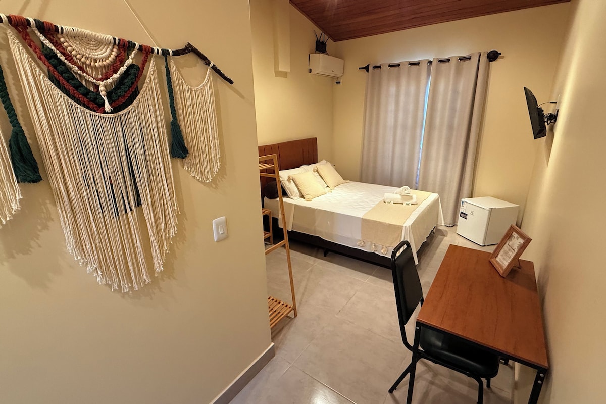 Un dormitorio con cama, mesita de noche y escritorio.