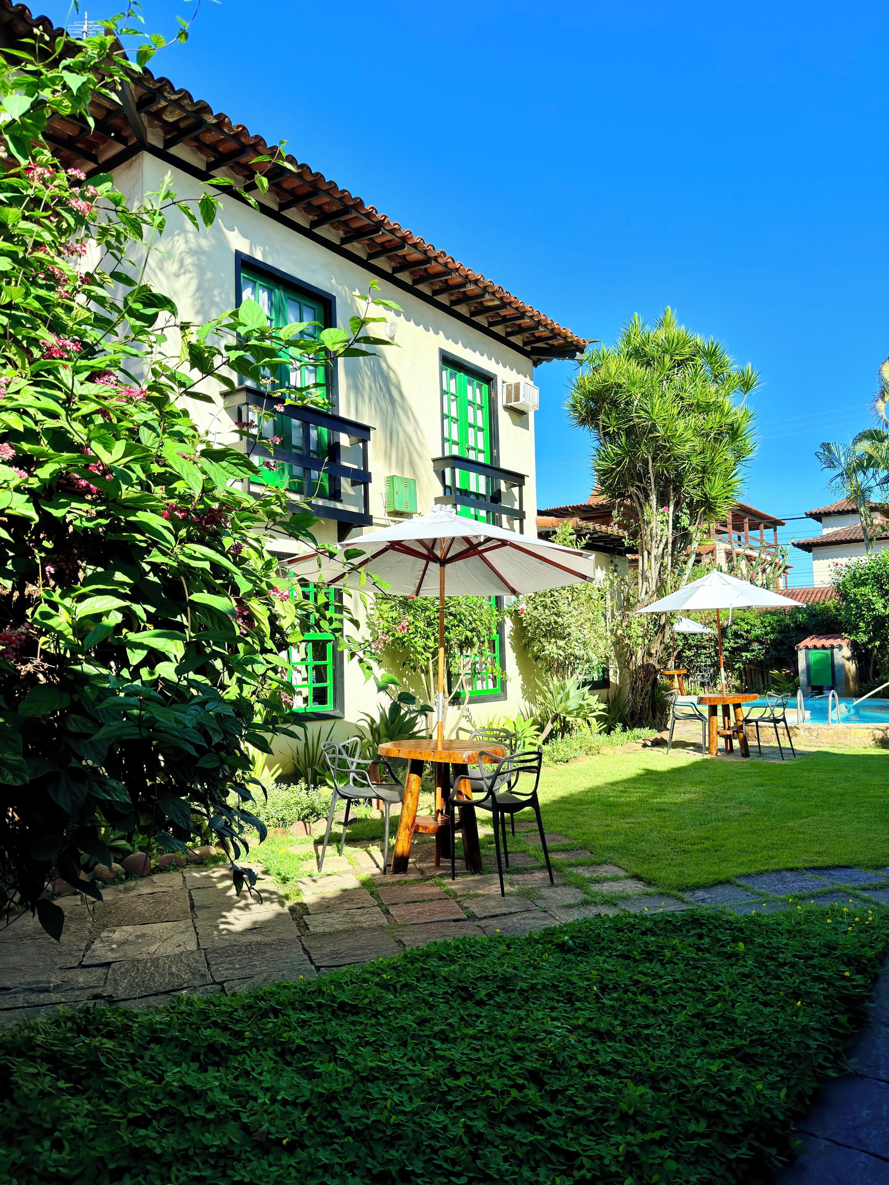 A building with a tiled roof, a balcony, and a pool area.