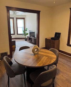 A dining area with a round wooden table, four chairs, and a vase. - Quaint 2-bedroom house in Detroit perfect for your getaway (Detroit)