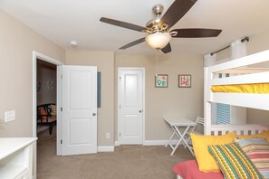 A bedroom with a ceiling fan, bunk beds, a desk, and a chair. - Crab House - Oceanfront w Pool, Hot Tub, Elevator & Backyard. Amazing Views! (North Topsail Beach)