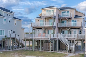 A beachfront property with multiple levels, wooden deck structures, and a staircase leading to the beach. - Crab House - Oceanfront w Pool, Hot Tub, Elevator & Backyard. Amazing Views! (North Topsail Beach)