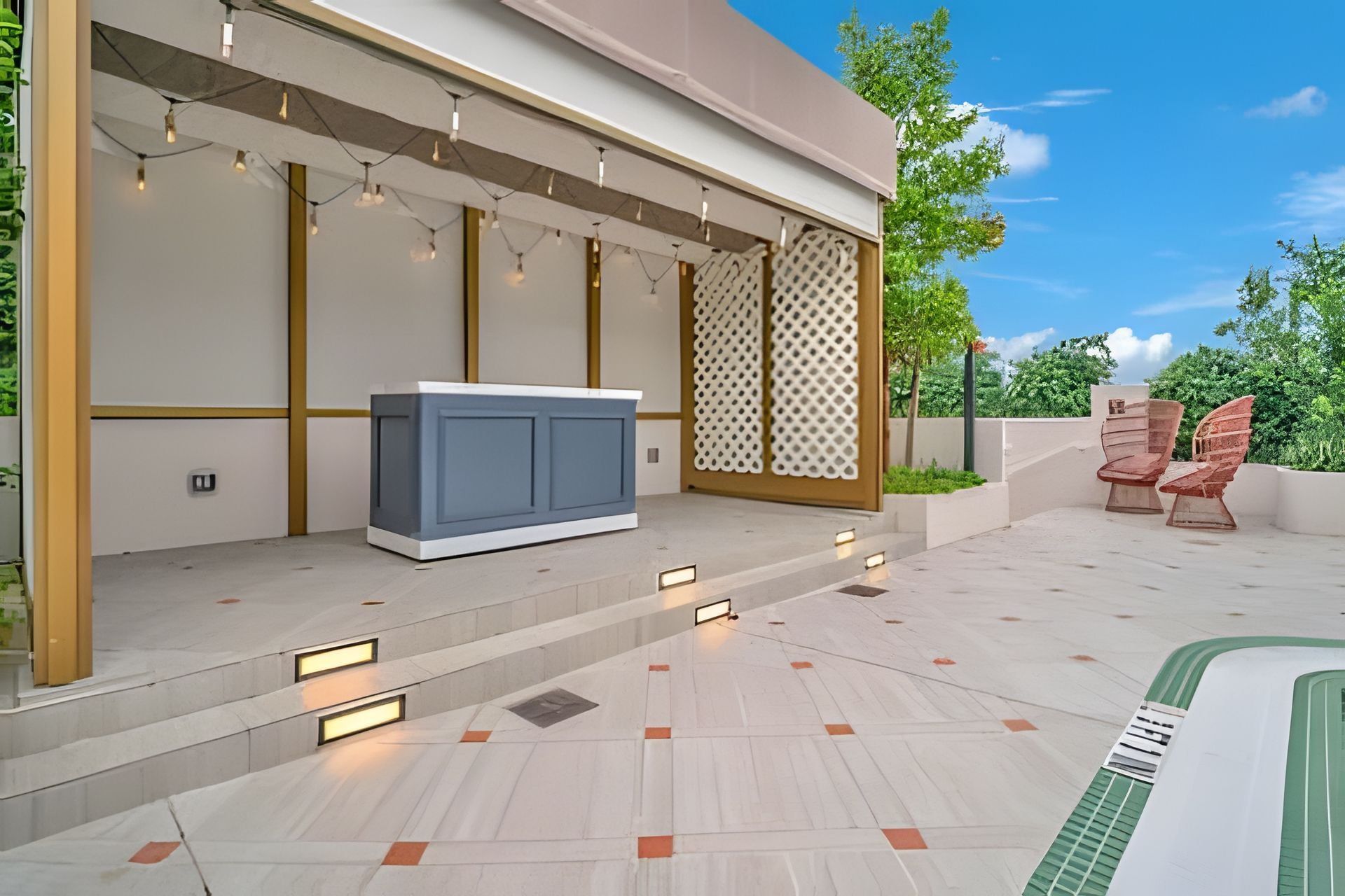 Un patio exterior moderno con piscina, zona de estar y una pared decorativa.