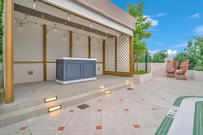 Um pátio moderno ao ar livre com piscina, área de estar e um muro decorativo.
