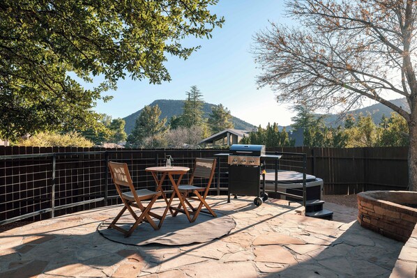 Patio esterno con barbecue, posti a sedere e vista sulle montagne.
