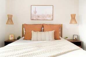 A bedroom with a large bed, two nightstands, a framed picture on the wall, and two hanging lamps. - Modern West Sedona Retreat - hot tub, firepit (Sedona)