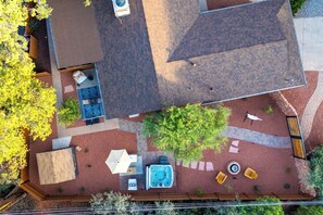 Ein Blick von oben auf einen Garten mit Whirlpool, Sitzgelegenheiten im Freien und einer Terrassenfläche.
