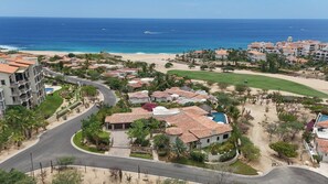 Ein Küstenresort mit mehreren Gebäuden, einem Strand und einem Golfplatz.