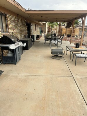 An outdoor patio area with a barbecue grill, seating, and a covered section. -  Snowbird Friendly. Monthly Discount
Delightful 4-bedroom home in Bullhead City. (Bullhead City)