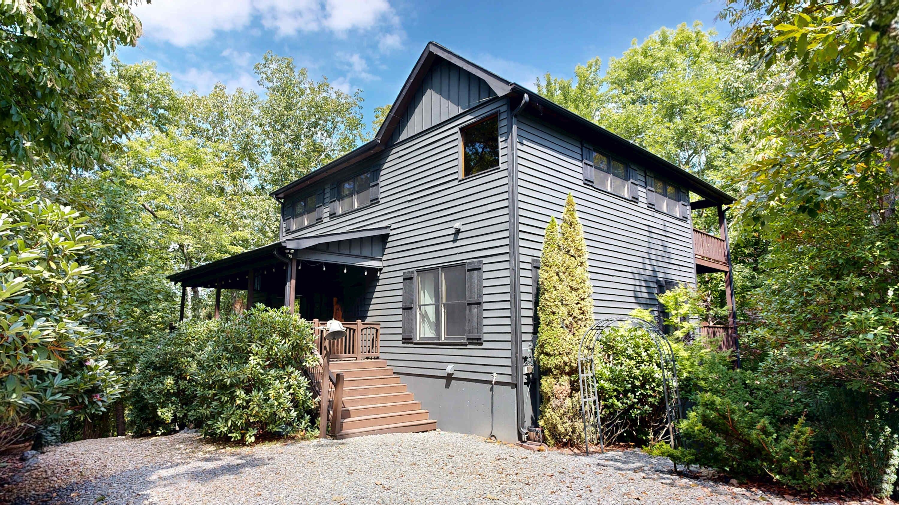 A two-story house with a covered porch and a staircase leading to the entrance.