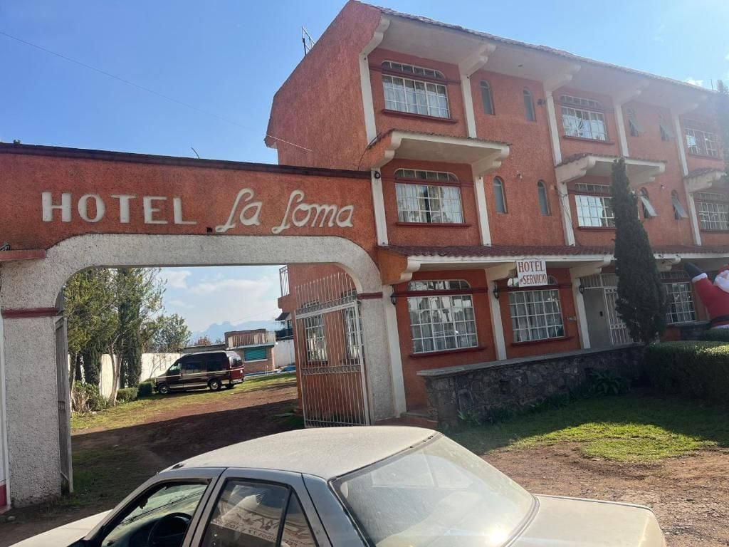Een gebouw met een bord waarop 'HOTEL La Soma' staat.