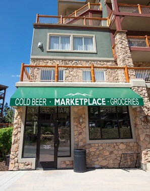 En byggnad med en butiksfasad där det står ”COLD BEER MARKETPLACE • LIVSMEDEL”.