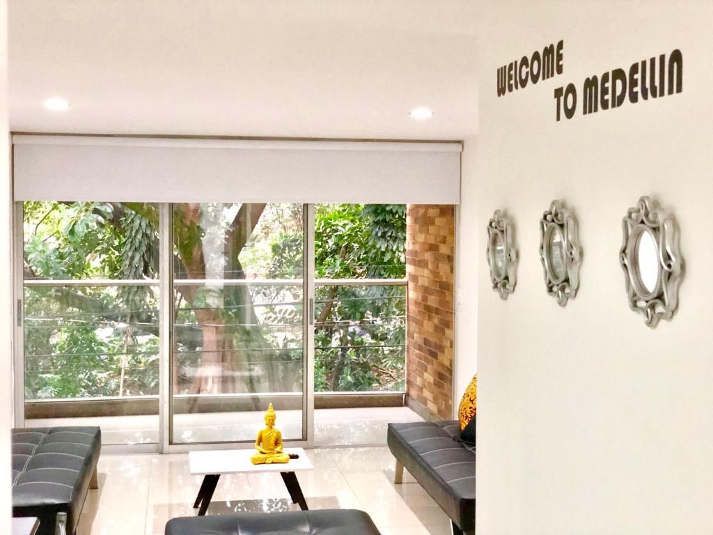 A reception area with a large window, a sofa, a small table, and a wall-mounted sign.