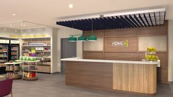 A modern hotel lobby with a reception desk, a snack area, and a sign reading 'HOME 2 SUITES BY HILTON'.