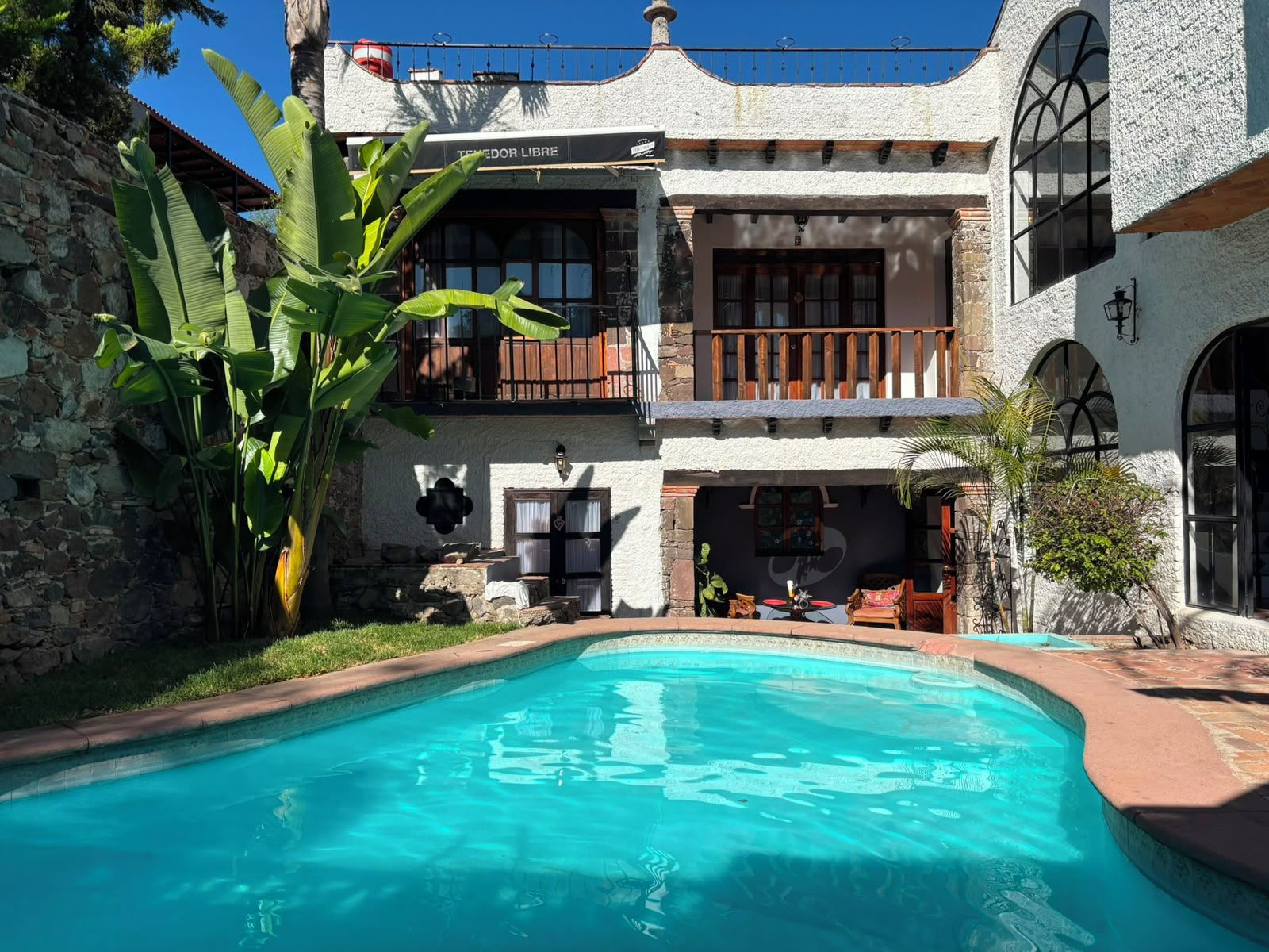 Un edificio de dos plantas con una piscina delantera.
