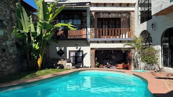 Un edificio de dos plantas con una piscina delantera.