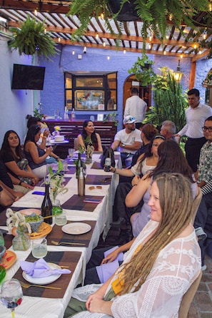 Un grupo de personas sentadas a una mesa con vista a un edificio al fondo.