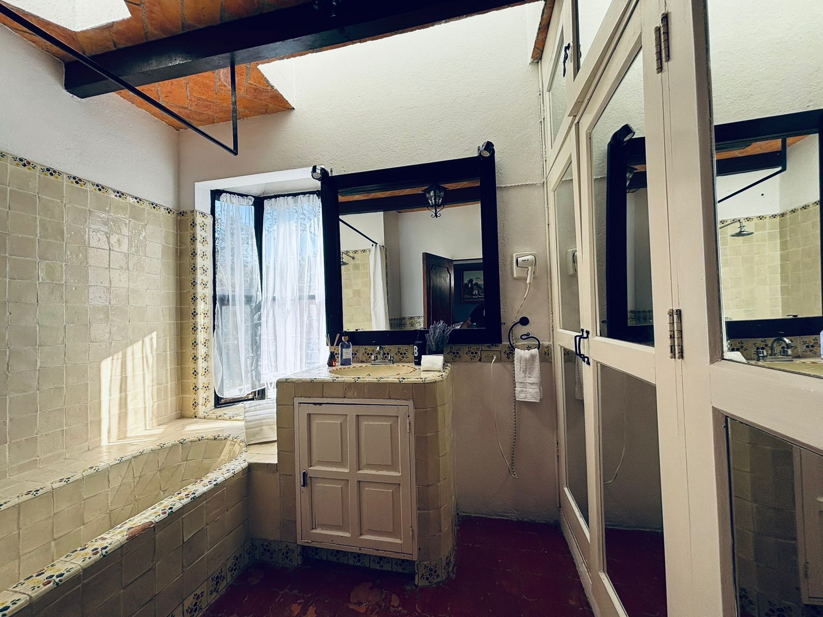 Een badkamer met een bad, een wastafel, een spiegel en een douche.