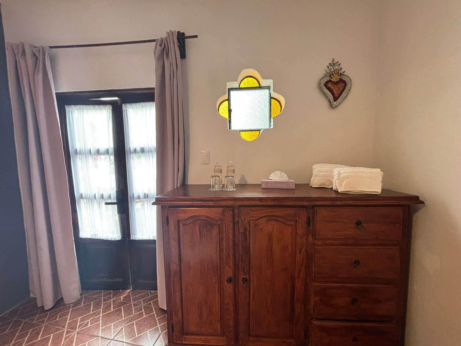 Une salle de bain avec un meuble-lavabo en bois, un miroir, un porte-serviettes et un élément décoratif mural.